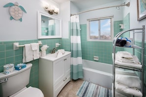 A bathroom with a toilet, sink, and bathtub.