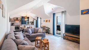 En modern lägenhet i loftstil med kök, matplats och vardagsrum.