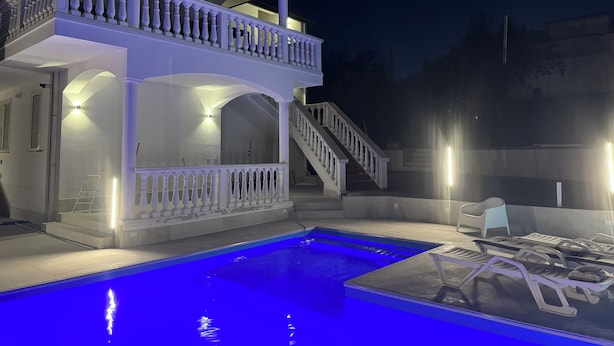 Um edifício de dois andares com varanda e piscina.