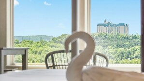 A swan-shaped centerpiece on a table with a view of a hotel and forested hills through large windows. - Beautiful Walk-in Lake View Condo with HA Features • Sunroom + Covered Patio (Branson)