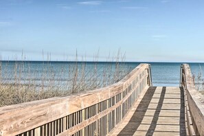 Un muelle de madera que conduce a una masa de agua bajo un cielo despejado.