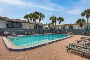 A rectangular swimming pool with a tiled edge, surrounded by lounge chairs and a brick patio. - < Half-Mi to Fort Clinch Beach! Condo w/ Balcony (Fernandina Beach)