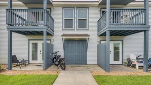 A two-story house with a front porch, a bicycle, and outdoor seating. - < Half-Mi to Fort Clinch Beach! Condo w/ Balcony (Fernandina Beach)