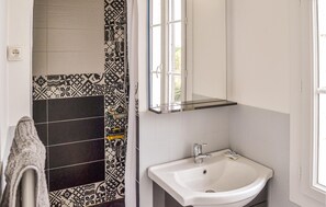 A bathroom with a white sink, a mirror, and patterned tiles. - Awesome home in Coutras with WiFi (Coutras)