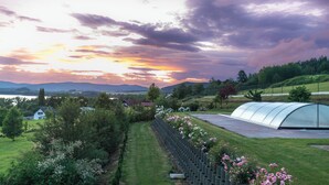 A greenhouse with a curved roof, surrounded by a well-maintained garden with flowering plants. - Villa-view, Pool, Bbq, Playground & Fire pit (Horni Plana)