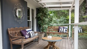 A wooden deck with a round table and two benches, surrounded by greenery. - The Grange country retreat, with a birds eye view! (Mittagong)
