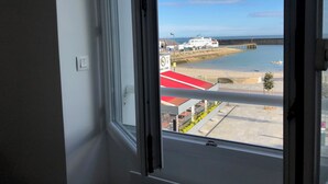 A view from a window overlooking a beach, a pier, and a restaurant named "Serie." - Apartment facing pier with sea view, WIFI and secure parking space (Quiberon)