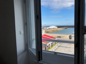 A view from a window overlooking a beach, a pier, and a restaurant named "Serie."