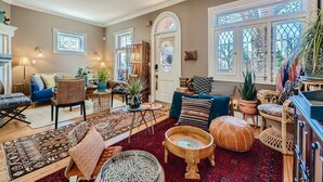 Un salon chaleureux avec un canapé bleu, des tapis à motifs et une table basse en bois.