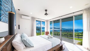 Une chambre dotée d’un grand lit, offrant une vue sur l’extérieur et présentant un design moderne.