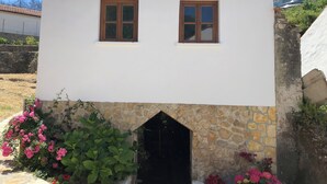 Un piccolo edificio con due finestre, una base in pietra e un ingresso modesto.