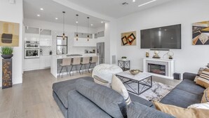 Una sala de estar moderna con un sofá gris, una mesa de centro y una chimenea.