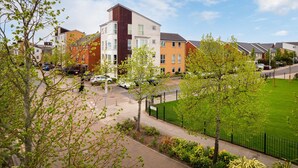 Ein Wohngebiet mit modernen Häusern, einem grünen Rasen und einem Fußweg.
