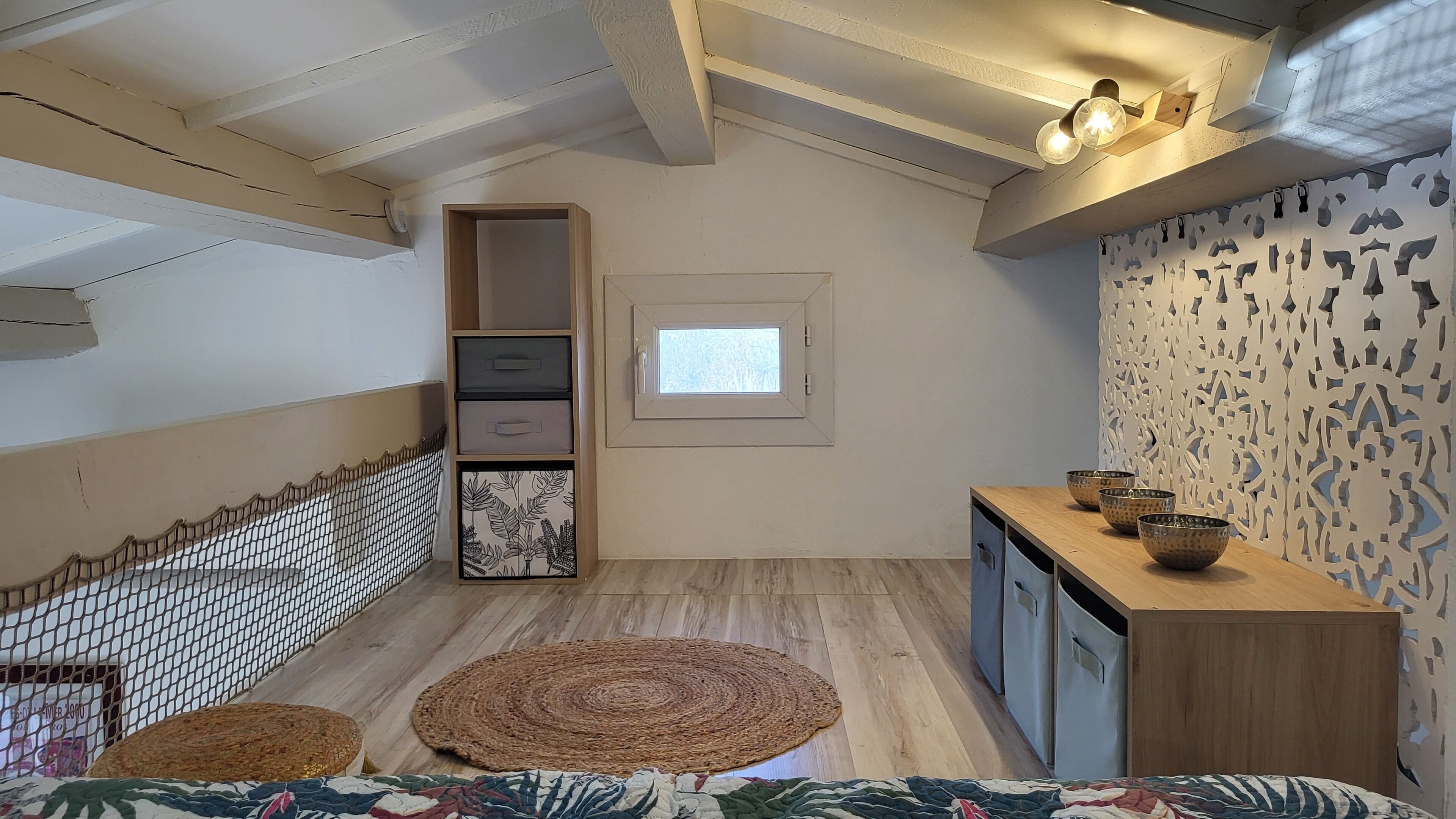 A compact kitchen with a wooden countertop, a small window, and a decorative wall panel.