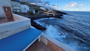 A coastal building with a blue exterior and a view of the sea. - House above the sea. Impressive. (La Puente)