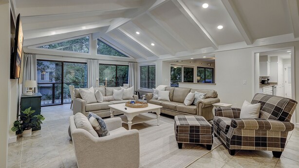 A spacious living room with a large window, a fireplace, and a dining area. - 7 Bald Eagle-3 Row Ocean (75 yards) to the Beach &  40 ft x 10 ft Pool (Hilton Head Island)