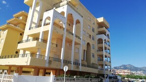 A multi-story building with balconies and a gated entrance. - El pilar 6º Solo familias! (Xeraco Playa)