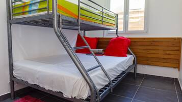 A bunk bed with a white mattress and a colorful blanket.