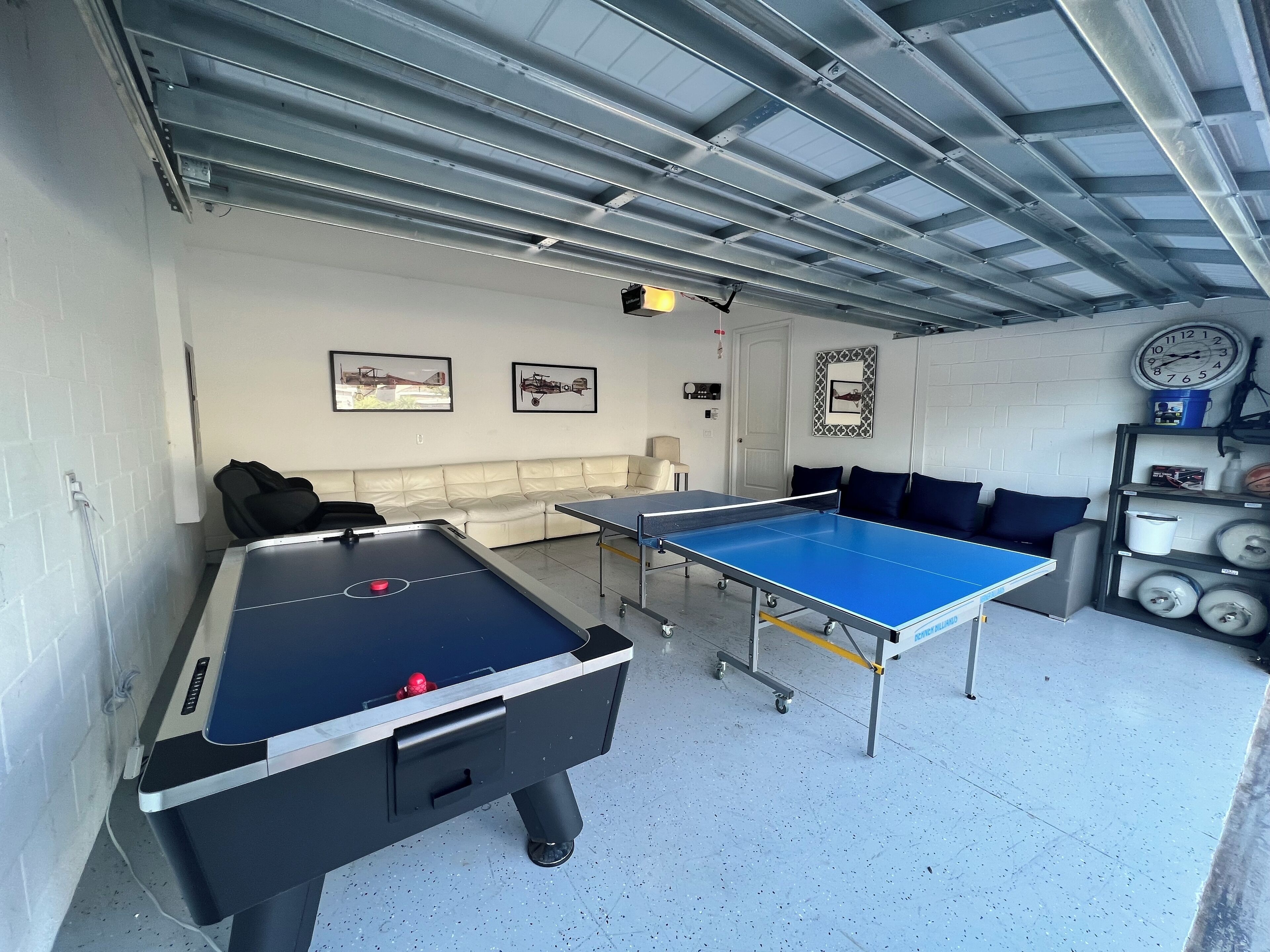 Ein Raum mit Kicker-, Tischtennisplatte und einer Couch.