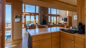 Una cocina amplia con chimenea de piedra, ventanas grandes y vistas al exterior.