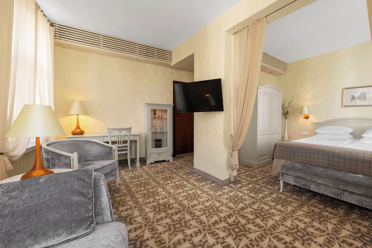 Une chambre d’hôtel comprenant un lit, un bureau avec une chaise, une télévision et un placard.