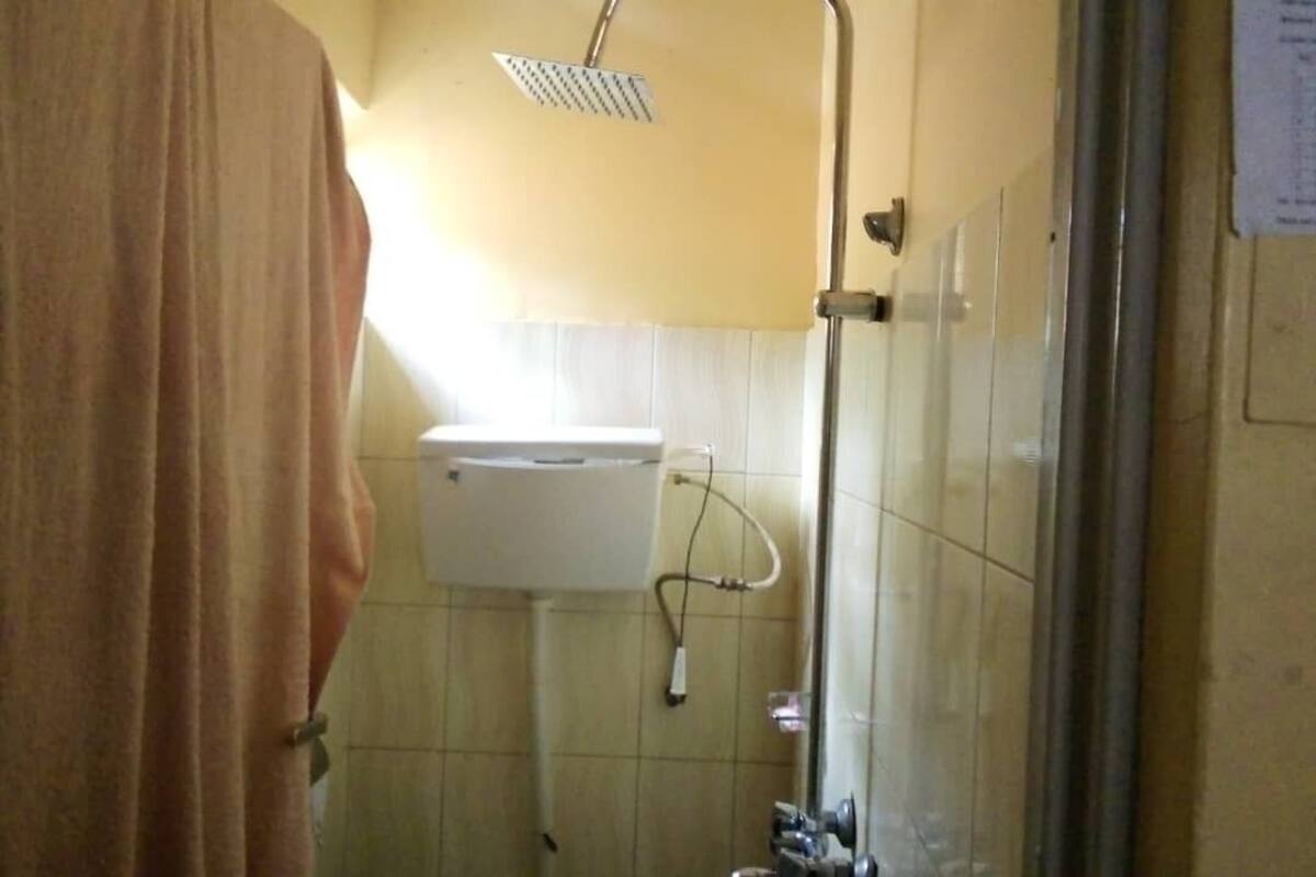 Een badkamer met douche, toilet en wastafel.