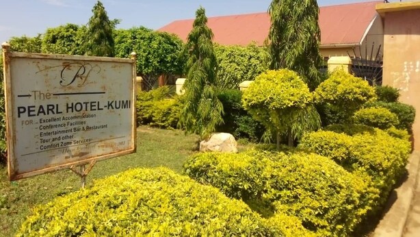 A sign for the Pearl Hotel-Kumi, listing amenities like conference facilities, entertainment bar, and restaurant. - The Pearl Hotel Kumi (Kumi)