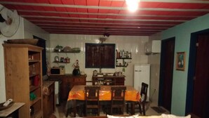 Un espacio habitable compacto con comedor, kitchenette y sofá con cojines.