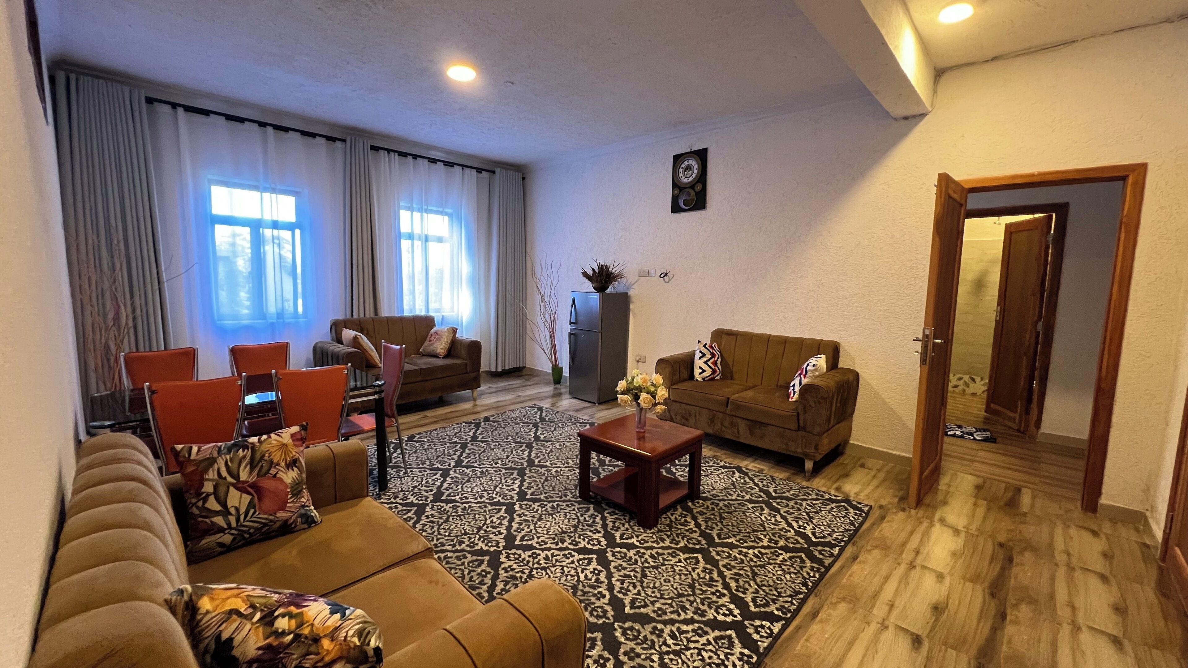 A living room with two sofas, a coffee table, and a dining area with chairs.