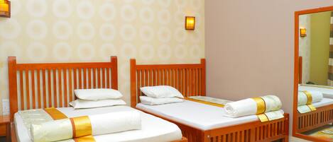Una habitación de hotel con dos camas de madera, ropa de cama blanca y un espejo grande.