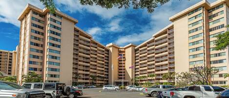 A multi-story hotel with a parking lot in front.