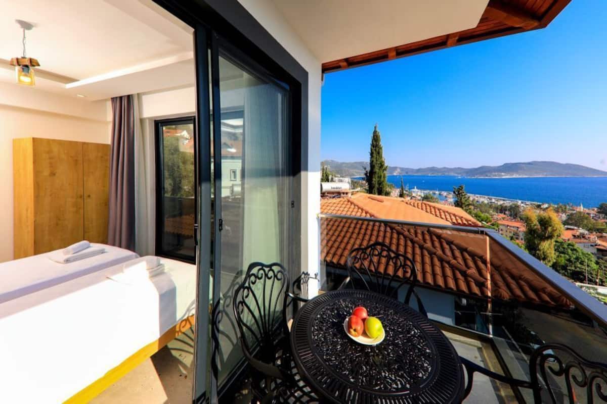 Un balcon avec un lit, une table avec des fruits et une vue sur la mer.