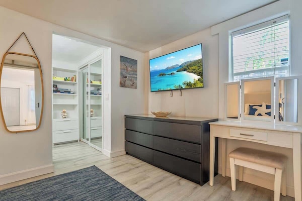 Cozy coastal bedroom with a luxurious mattress for dreamy sleep, smart TV for streaming, and serene beachy vibes.