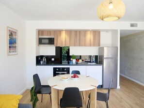 A modern kitchen with wooden cabinets, a built-in microwave, and a stainless steel refrigerator.
