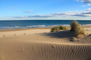 A sandy beach with gentle waves and a clear sky.