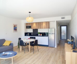 A modern apartment with a kitchen, dining area, and living room.