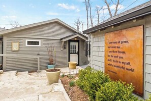 A house with a garden, a sign with a poem, and a mailbox.