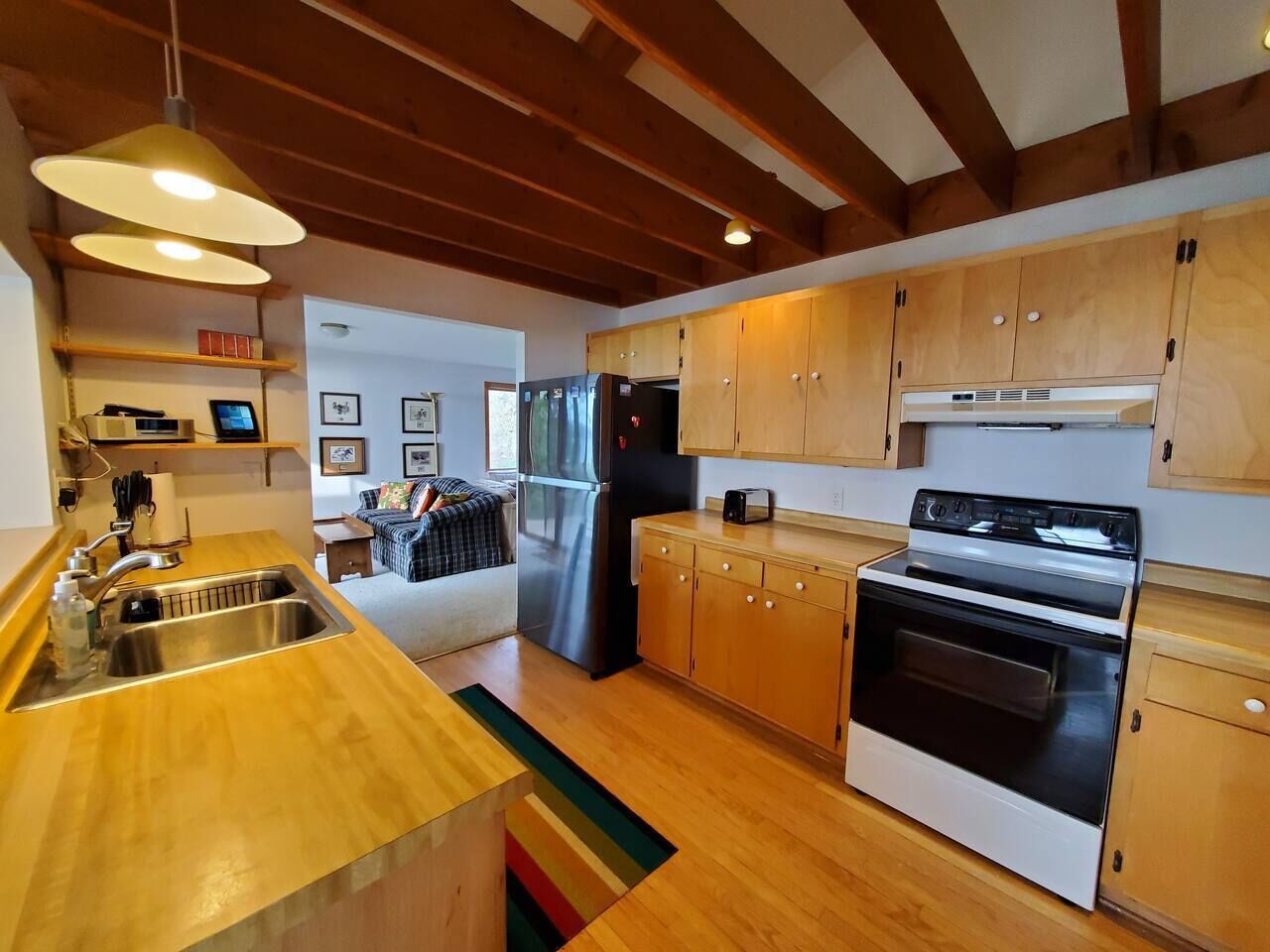 Una cocina moderna con armarios de madera, electrodomésticos de acero inoxidable y encimera de madera.