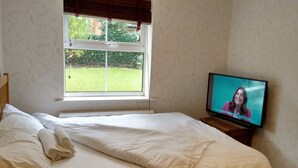 Makuuhuone, jossa on sänky, ikkuna ja televisio.