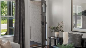 Een moderne woonkamer met een marmeren salontafel, een bank, een potplant en een plafondventilator.