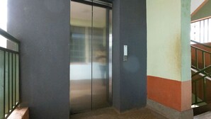 An elevator in a building with a metal door and a control panel on the wall. - Cozy Family-sized 2 Bedroom Apartment with stable Wi-fi & conducive work station (Ruiru)