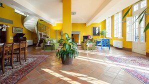 A spacious living area with a spiral staircase, a fireplace, and large windows allowing natural light. - Old restored lemon house near the center (Lucca)