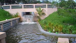 A water feature with a waterfall, surrounded by greenery and a stone wall. - TINY HOUSES TO RELAX IN THE COUNTRYSIDE ITAI AVARÉ HOLAMBRA II REP JURUMIRIM (Itaí)