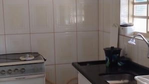 A kitchen with white cabinets, a black countertop, and a stove. - TINY HOUSES TO RELAX IN THE COUNTRYSIDE ITAI AVARÉ HOLAMBRA II REP JURUMIRIM (Itaí)