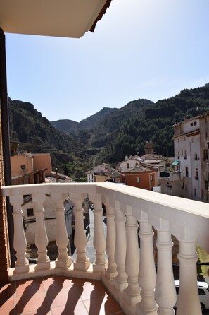 Un balcón con vista a un paisaje montañoso y edificios.