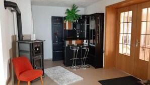 A compact kitchen with a built-in stove, black cabinets, and a wooden door.