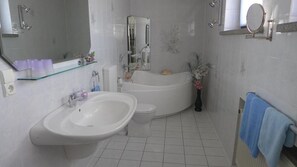Bathtub, hair dryer, towels, toilet paper
