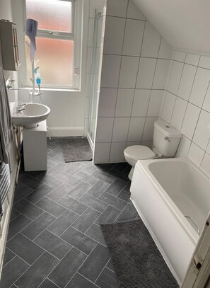 A bathroom with a toilet, sink, and bathtub.