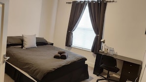Une chambre à coucher avec un lit, un bureau et une chaise.