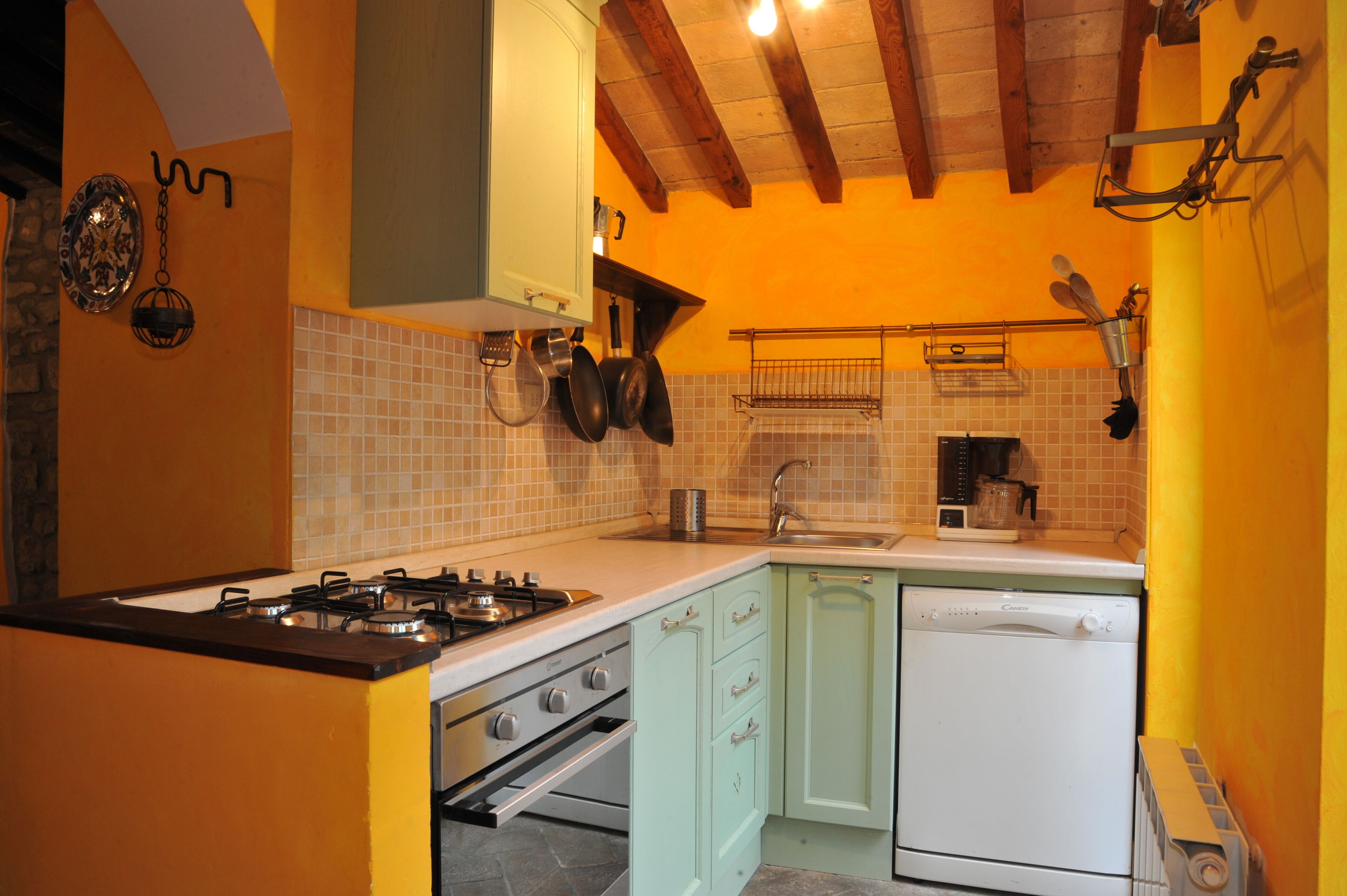 Cozinha equipada com fogão a gás, forno, lava-louças e painel de azulejos.